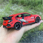 Red Honda model car held in a hand with a blurred natural background